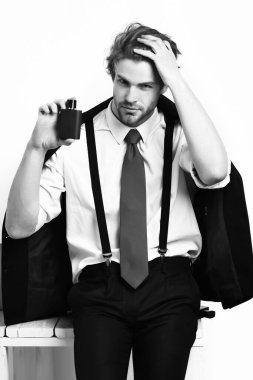 Beyaz adam parfümle poz veriyor.