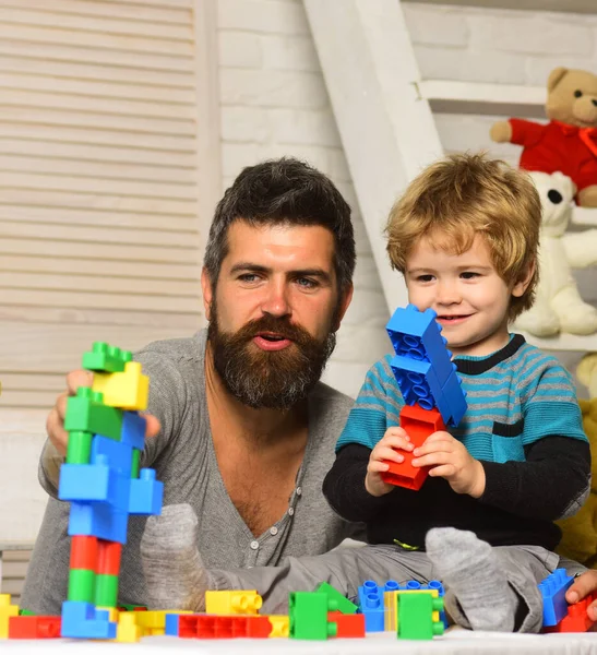 Padre e hijo con caras felices crean construcciones coloridas — Foto de Stock