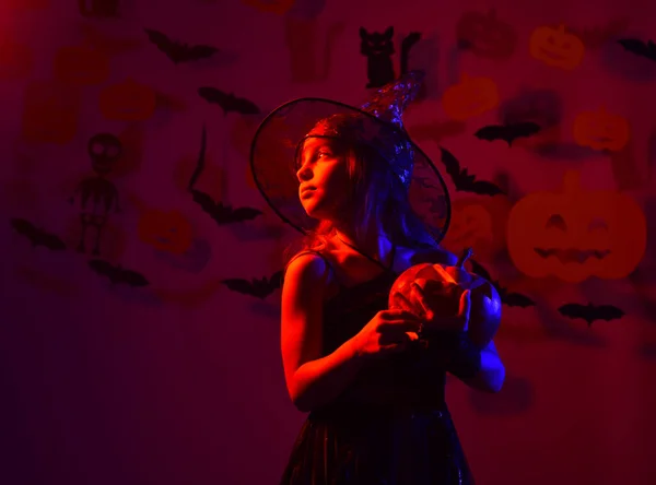 Kind in griezelige heksen kostuum houdt jack o lantaarn — Stockfoto