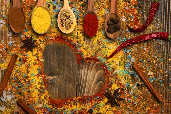 Composition of condiment making heart shape. Wood spoons