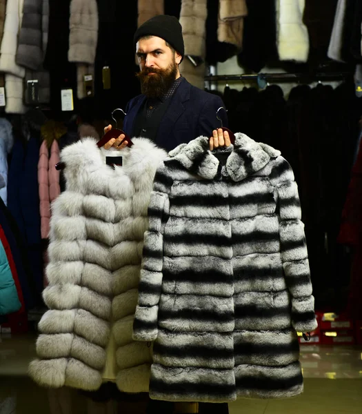 Şapkalı ve pahalı paltolu bir iş adamı. Sakallı müşteri kürklü manto seçer.. — Stok fotoğraf