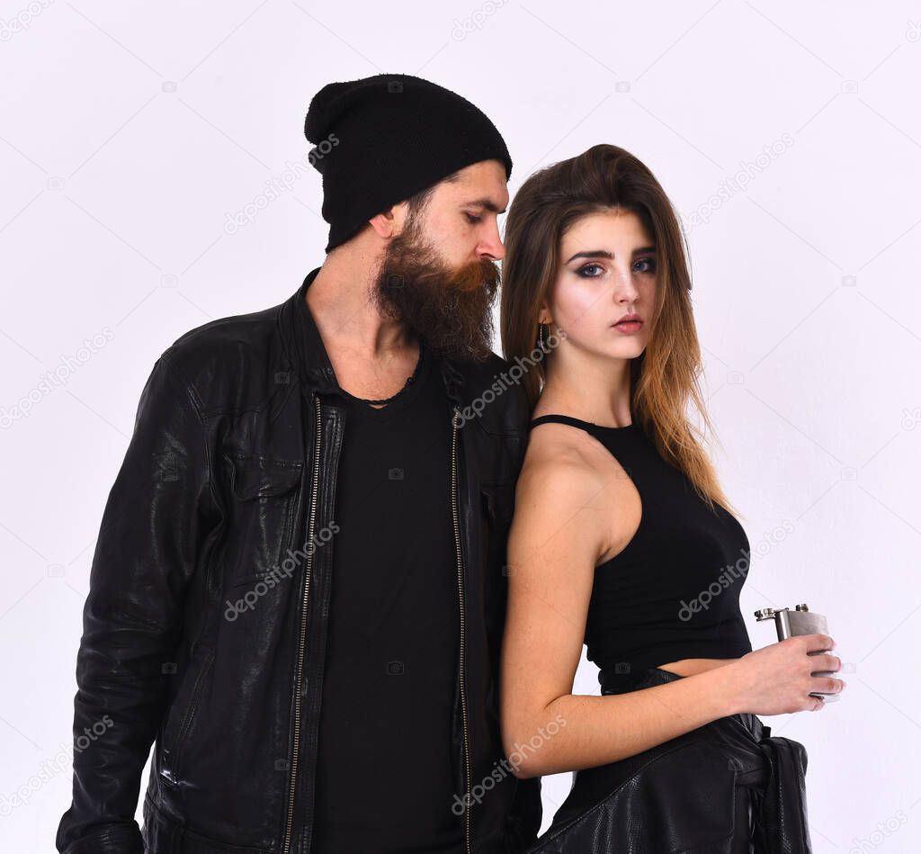 Girl and bearded man in black leather jacket pose together.