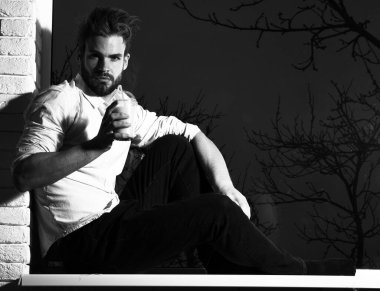 Yakışıklı, sakallı, seksi adam siyah ve tuğla duvar arkasında, kopyalama alanı