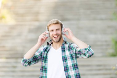 Kulaklıklarıma aşık oluyorum. Mutlu adam dışarıda kulaklık takıyor. Yakışıklı adam kulaklıkla müzik dinliyor. Yeni teknoloji. Modern hayat. Kulaklıklar kulaklarını güvende tutmak ve müziğin sesini yüksek tutmak için.