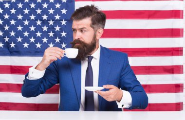 Hakkı olan bir ülke. Sakallı adam kahve fincanı içer. 4 Temmuz 'da Amerikan eğitim reformu. Amerikan bayrağında Amerikan vatandaşı. Tribünde kahve içmek. Seçimde Amerikalı politikacı. Seçim kampanyası