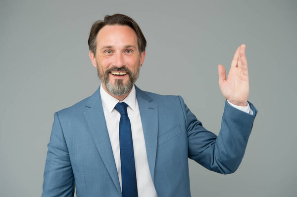Businessman smiling mature man waving hand, welcoming clients concept