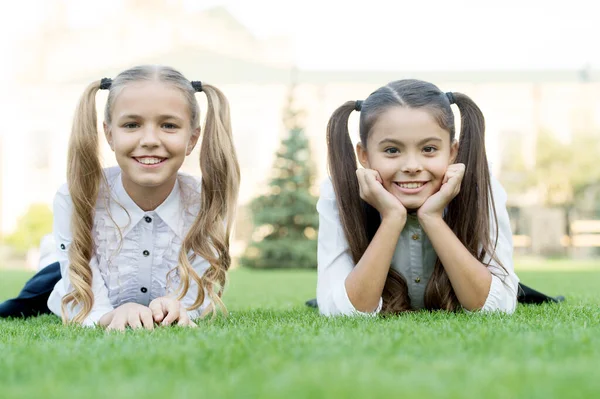Schoonheid is wat vreugde geeft. Gelukkige kinderen ontspannen op groen gras. Schoonheid van kleine meisjes. Childs huidverzorgingsproducten. Schoonheidssalon. Schoonheidscosmetica. Zomervakantie. Schoolvakanties. Voel je mooi. — Stockfoto