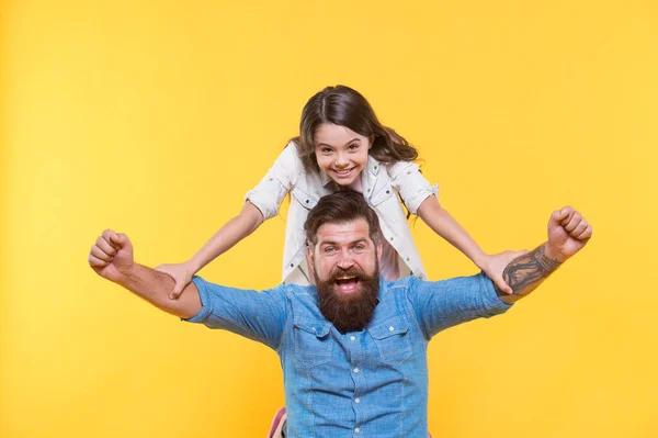 Love in our family grows deep. Happy family celebrate yellow background. Father and little daughter winth winning gesture. Bearded man and small child. Family values. Always there to always care
