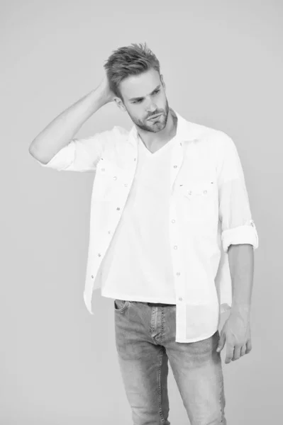 Homme d'affaires en jeans et chemise. portrait de l'homme millénaire en vêtements décontractés. Un bel homme porte un t-shirt blanc et pose en studio. C'est plutôt beau. Mode de vie urbain décontracté — Photo