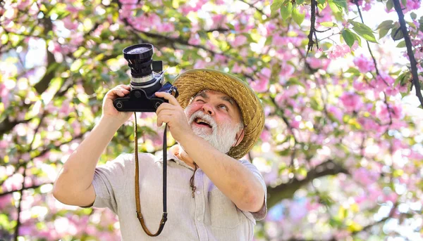 Senior man hold professional camera. Photography courses. Happy grandfather. Travel and tourism. Spring holidays. Travel photo. Retirement travel. Capturing beauty. Photographer in blooming garden — Stock Photo, Image