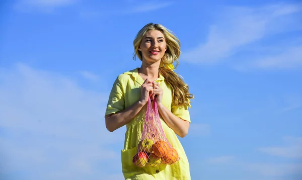 Sustainable lifestyle. Reusable cotton and mesh eco bags for shopping. Girl summer day blue sky background. Eco aware. Woman carry fruits and vegetables in eco bag. Zero waste. Plastic free concept
