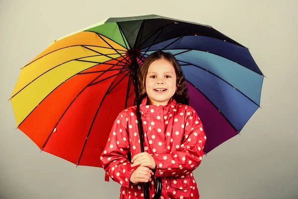 가을 시즌. 행복 한 소녀는 화려 한 무지개 우산을 들고 있다. 적절 한 옷을 입은 날씨. 좋은 하루되 세요. 우산 아래를 걷는게좋을 거야. 비가 온 후에는 언제나 무지개가 있다. 비개념을 즐기라 — 스톡 사진