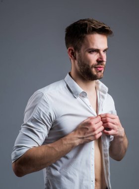 Seksi yakışıklı erkek. Seksi adam bakıyor. Gömlekli yakışıklı bir adamın portresi. Beyaz baskılı klasik erkek gömlekleri. Yakışıklı, kendine güvenen, gömlekli genç bir adam.
