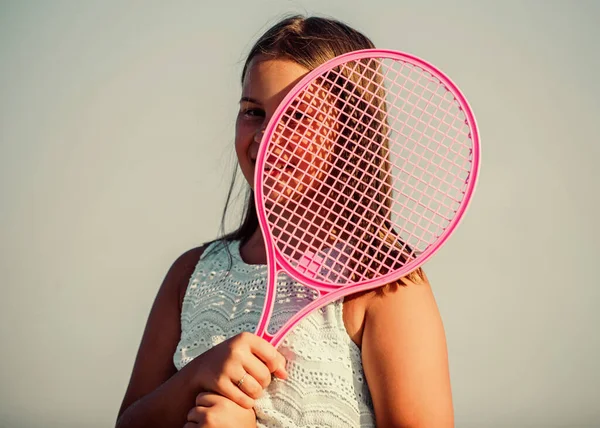 İçinde enerji var. Oyun oynuyor. Açık hava oyunları. Tenis oyna. çocukluk mutluluğu. Sağlıklı bir yaşam tarzı. Tenis raketli küçük bir kız. Yaz sporları aktivitesi. Enerjik çocuk. Mutlu ve neşeli. — Stok fotoğraf
