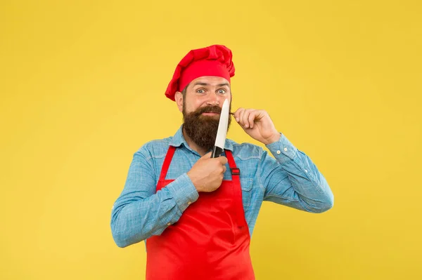 Bra mat och service. Brutal slaktare i förkläde. bästa meny erbjudande. självsäker skäggig glad kock röd uniform. Man kock skuren med kniv. mogen hipster med glatt ansikte. nöjd skäggig kock — Stockfoto