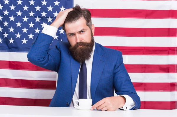 Αμερικανός πολιτικός στις εκλογές. την προεκλογική του εκστρατεία. Ο γενειοφόρος πίνει καφέ. Αμερικανική εκπαιδευτική μεταρρύθμιση τον Ιούλιο 4. Αμερικανός πολίτης με σημαία ΗΠΑ. πίνοντας καφέ σε tribune — Φωτογραφία Αρχείου
