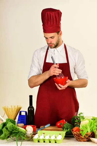 Chef con la cara ocupada sostiene el tazón y batir en blanco — Foto de Stock