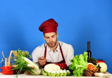 Mutfak eşyaları ve yemek pişirme konsepti. Aşçı şapkalı ve önlüklü adam.