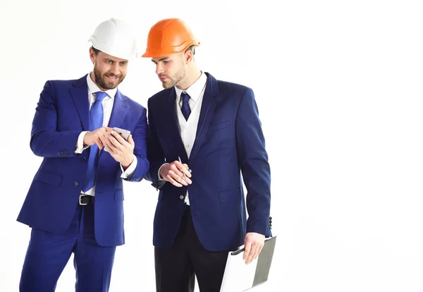 Ondernemer en architect met plannen en smartphone. — Stockfoto