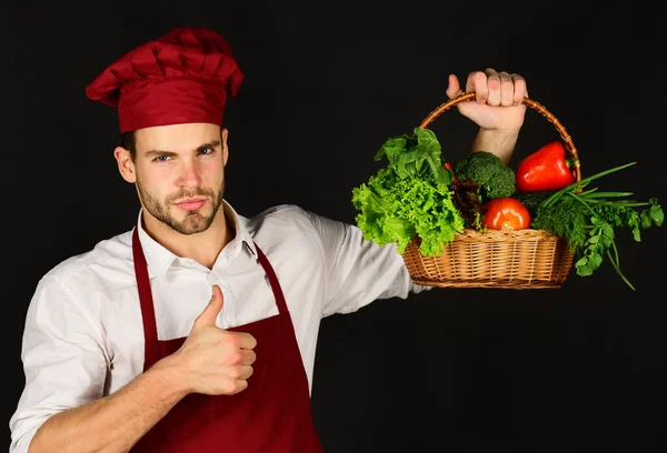 Koch hält Gemüse in Holzkorb und zeigt Daumen hoch. — Stockfoto