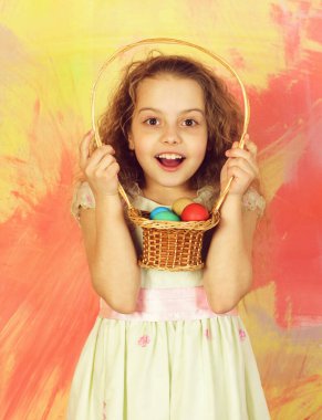 Renkli arka planda yumurta sepeti olan mutlu Paskalya kızı.