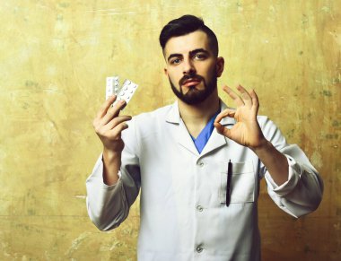 Sakallı ve şık saç kesimli doktor iyi bir jest yapıyor.