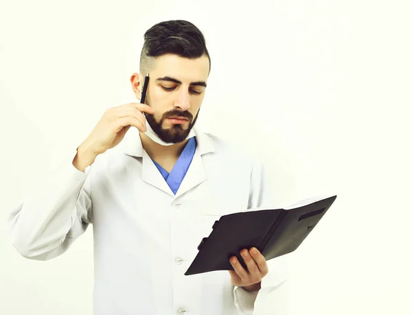 Arzt mit Bart liest Krankengeschichte in Notizbuch — Stockfoto