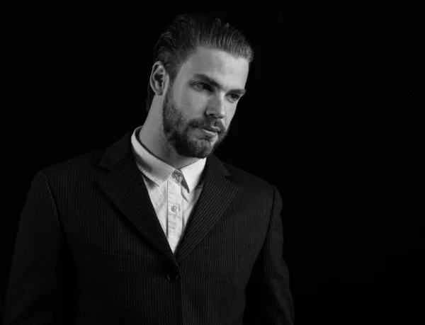 business man in black suit on black background, copy space