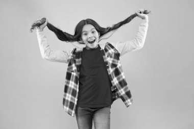 Uslu bir kız olmak. At kuyruklu küçük kız pembe arka plan. Mutlu kız uzun saçlı. Küçük kız sıradan bir şekilde gülümsüyor. Güzellik salonu. Kuaför salonu. Moda ve tarz. Çocukluk ve kızlık