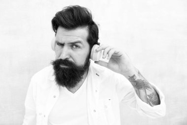 Mükemmel bir fikir. Elektronik dans müziği ve ev şarkıları. Enstrümantal müzik. Sakallı adam kulaklıkları arka planda. Hippi müzik kulaklığı dinler. Modern kablosuz kulaklıklar