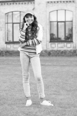 Etrafta dolaşırdı. Liseli kız şapka takıyor. Gündelik tarz ve şapkalı bir genç. Çocukluk mutluluğu. Kıvırcık saçlı, şapkalı mutlu kız. Çocuk dışarıda gülümsüyor. Güzellik ve moda. Yürüyen yeşil çimenler