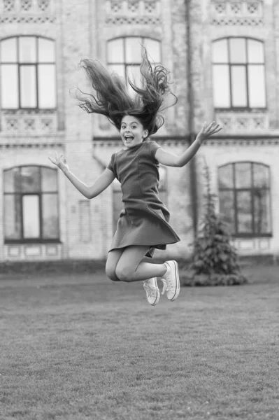 Menina pulando ao ar livre. Fique à vontade. Salto de felicidade. Menina pequena saltar na grama verde. Cheio de energia. Menina ativa sentir a liberdade. Diversão e relaxe. Miúdo despreocupado nas férias de verão. Adolescente em vestido rosa — Fotografia de Stock