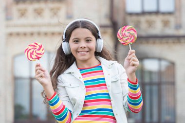 En sevdiği tatlı. Kulaklıklı kız. Üzerinde lolipop olan kablosuz kulaklıklı küçük bir kız. Okula dönüyorum. Yeni teknolojiyle modern eğitim. Okul bahçesindeki çocuk. Sağlıklı yemek. Çocuğun müzik molası var.