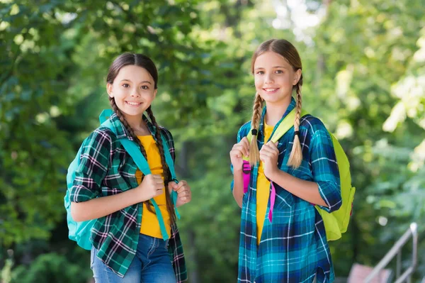 Progressive pupils. girls with school bags. child with backpack. happy time. Fashion little girls with backpack in park. children with backpack smiling. students outside in summer park smiling happy