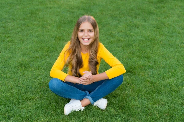 행복하게 미소짓는 작은 소녀, 편안 한 풀밭, 흥분 한 아이 개념 — 스톡 사진