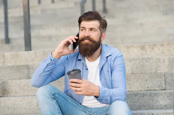 Pleasant conversation. Real connect. Drink coffee while talking. Modern urban life. Bearded man phone conversation. Mobile conversation. Coffee break. Personal communication. Calling friend