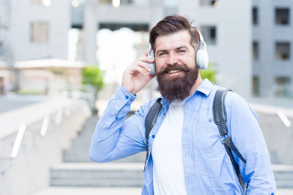 Bel suono. Rotta giornaliera per lavorare. La vita moderna. Uomo con le cuffie a piedi centro città. Ascolto musica. Bellissimo hipster con zaino che cammina per strada. Camminare per strade vuote. Da solo con la musica — Foto Stock