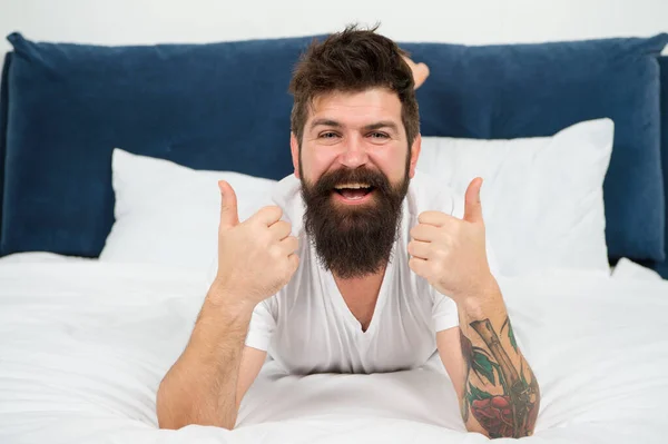 Erkek mutlu sakallı yüz evde yatakta rahatla, yumuşak yatak konsepti — Stok fotoğraf