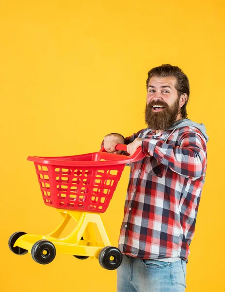 Mann in Einkaufszentrum. Kunden schieben Warenkorb. Käufer im Supermarkt. Leerer Spielzeugwagen. wirklich beschäftigt Haushälterin. perfekter Ehemann. Brauchen Einkaufsliste. Bärtiger Mann geht mit leerem Einkaufswagen einkaufen — Stockfoto