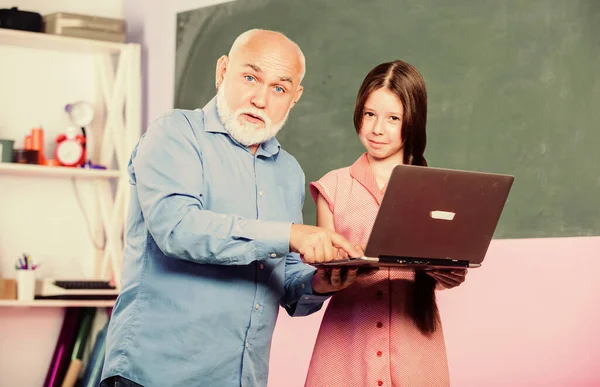 Zkušený pedagog. Online lekce. Přátelský pedagog. Zpátky do školy. Učím dítě. Učitel pomáhá školačce. Holčička s mužem doučování studovat držet notebook. Pedagog digitální vědy — Stock fotografie