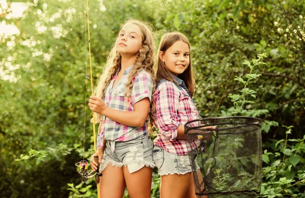 キャンプ活動。フライフィッシング。子供たちは一緒に釣りに時間を過ごす。釣りの技術。夏の趣味。ネットとロッドで幸せな笑顔の子供たち。幸せな子供時代。好色な女の子の性質の背景。チームワーク — ストック写真