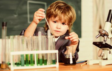 Dersteki küçük çocuk. Okula dönelim. Okulda kimya öğrenen küçük bir çocuk. Biyoloji laboratuarı ekipmanı. İlkokuldaki küçük çocuk. Bilim okuyan okul çocuğu bilim adamı. Kendine güvenen doktor.