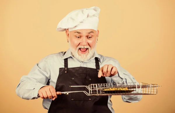 Barbecueën tot in de perfectie. de voorkeur grill voedsel. Picknick en barbecue. Keukenregels. Maak het eten klaar voor familie. Familieweekend. Oudere man met koksmutsen. Kook mannen met een baard. kookgerei voor de barbecue — Stockfoto