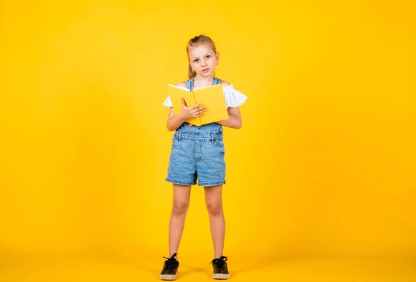 my childhood memories. Back to school and childhood concept. Pupil on yellow background. Kid with smart look and casual outfit. modern education concept. inspired with idea. Girl read the book