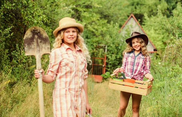 Zöld életet élni. ökológia és környezetvédelem. Földi nap. nyári családi farm. gazdálkodás és mezőgazdaság. Tavaszi vidék. Kislányok farmerek a faluban. a gyermekek kertészeti eszközöket tartanak — Stock Fotó