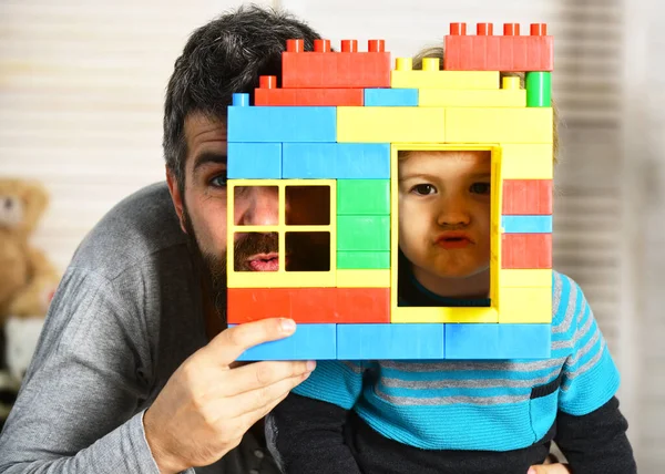 Baba ve çocuk bloklardan yapılmış duvarın arkasına saklanıyor. — Stok fotoğraf