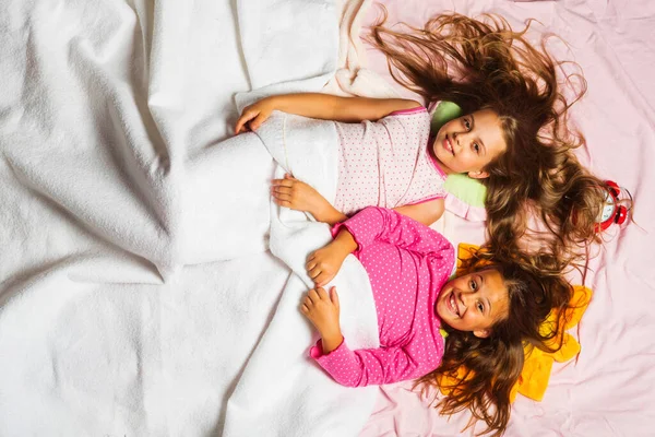 Gyerekek mosolygós arcok és laza haj rózsaszín háttér — Stock Fotó