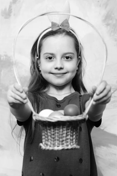 Маленькая счастливая девочка держит корзину с пасхальными яйцами — стоковое фото