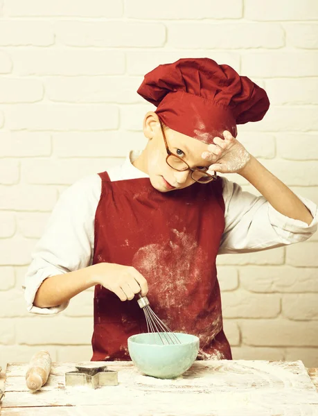 Obarvený roztomilý kuchař kluk na bílém cihlové zdi pozadí — Stock fotografie