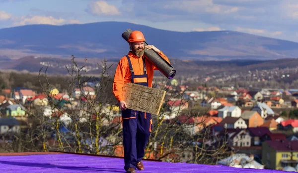 Ama il suo lavoro. Operaio Roofer in abiti da lavoro speciali protettivi. nuovo tetto in costruzione edificio residenziale. costruttore utilizzare feltro di copertura. tettuccio professionale master repair. Installazione tetto piano — Foto Stock